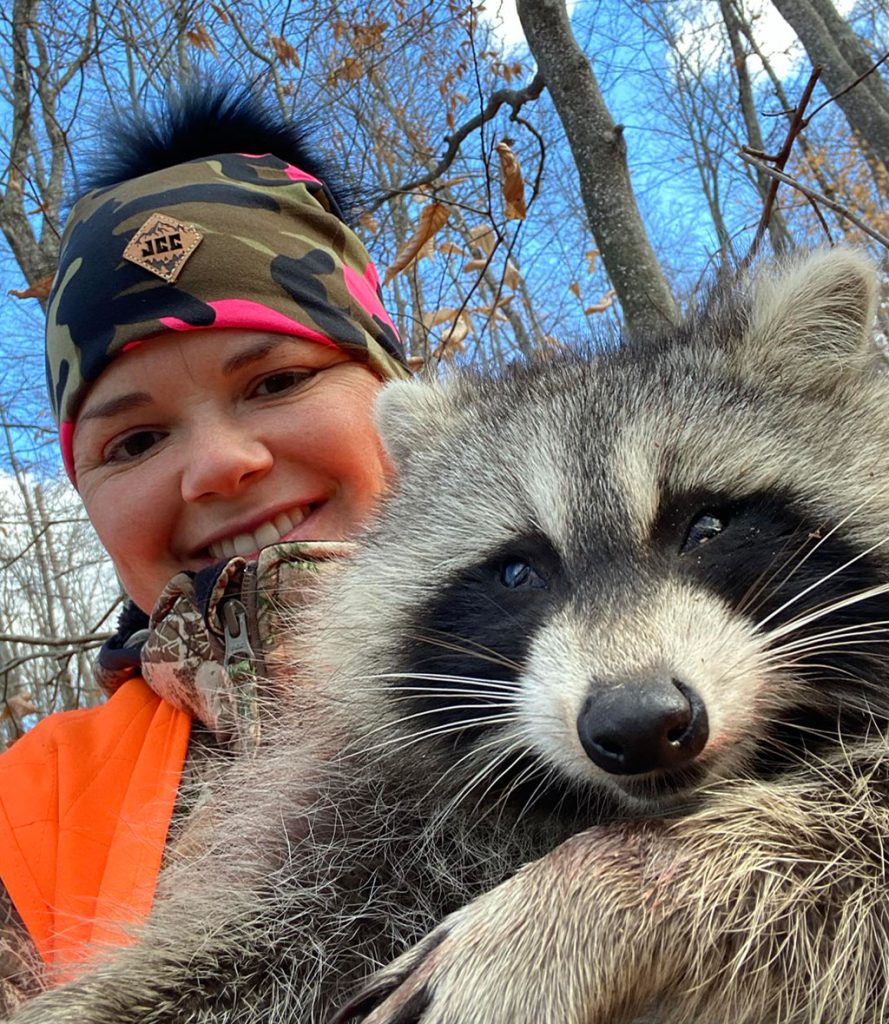 female trapper with raccoon